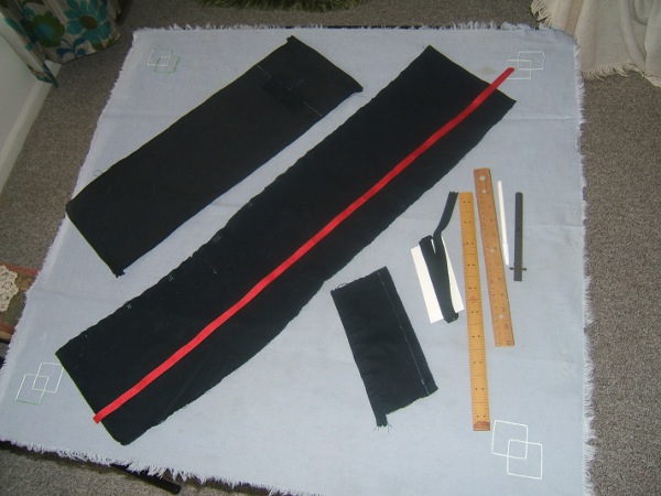 wallet parts on card table:  duck outer casing, broadcloth strip 
                     to be torn into pockets, cards pocket, red twill 
                     tape, black twill tape